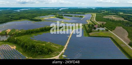 Vista aerea dei campi di pannelli solari nel comune di Middleburg in una zona verde con un fiume sullo sfondo Foto Stock