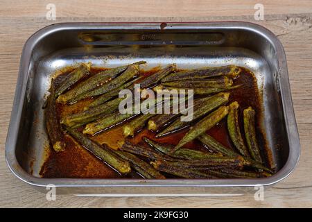 Okra torrefatto in forno speziato in un piatto di tostatura in acciaio inossidabile, Inghilterra, Regno Unito, Europa occidentale. Foto Stock