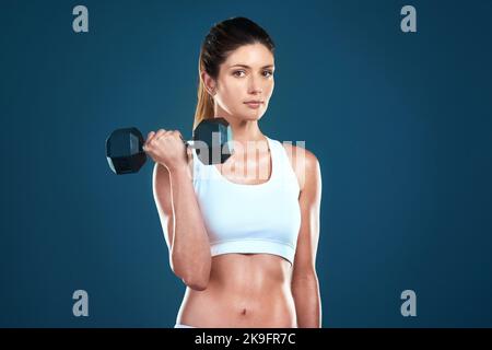 Non rinunciare al corpo che si desidera. Foto studio di una giovane donna in forma che si posa su uno sfondo blu. Foto Stock