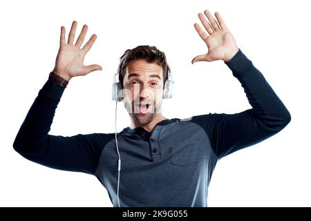 Quando non puoi smettere di ascoltare la tua nuova canzone preferita. Studio ritratto di un bel giovane uomo utilizzando le cuffie su uno sfondo bianco. Foto Stock