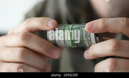 Uomo che tiene in mano cento dollari fatture Foto Stock