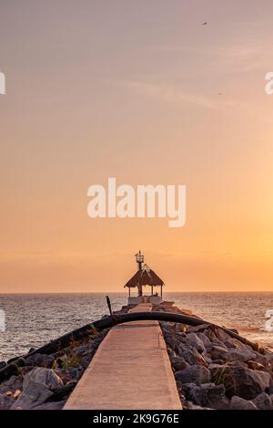 Un vecchio molo rotto con uno sfondo dorato tramonto Foto Stock
