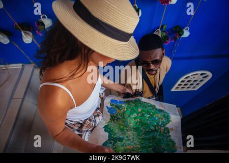 Due giovani turisti stanno guardando la mappa prima di lasciare il bar. Stanno per continuare ad appendere fuori Foto Stock