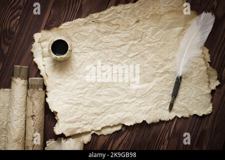 Carta vecchia, chiocciola e penna su carta di legno con spazio di copia Foto Stock