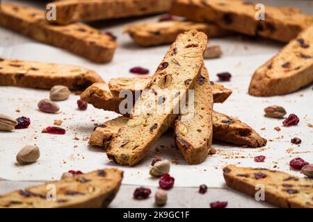 Biscotti impilati verticalmente con mirtilli rossi e pistacchi. I biscotti o i cantucci sono tipici biscotti dolci italiani cotti al forno Foto Stock