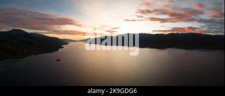 Un'alba serena illumina Kalabahi Bay circondata dall'isola di Alor, Indonesia. Questa zona delle Isole minori di Sunda ha un'elevata biodiversità marina. Foto Stock