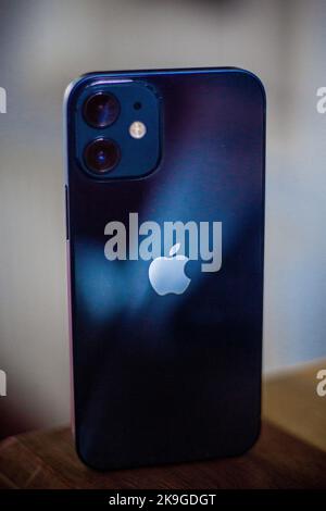 Immagine verticale di un iPhone 12 Mini blu in piedi. Foto Stock