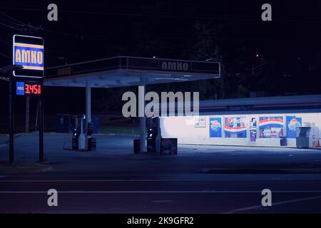 una stazione di servizio di notte in colori blu Foto Stock