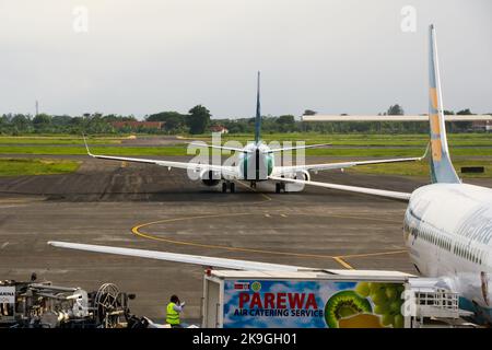 Vista dell'aereo di linea di Garuda Indonesia sulla pista dell'aeroporto internazionale di Juanda con nuvole sullo sfondo blu del cielo. Nessuna gente. Foto Stock