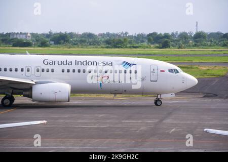 Vista dell'aereo di linea di Garuda Indonesia sulla pista dell'aeroporto internazionale di Juanda con nuvole sullo sfondo blu del cielo. Nessuna gente. Foto Stock