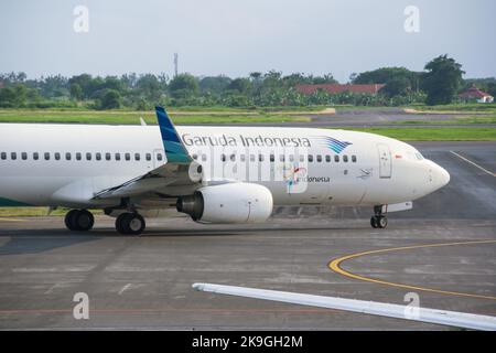 Vista dell'aereo di linea di Garuda Indonesia sulla pista dell'aeroporto internazionale di Juanda con nuvole sullo sfondo blu del cielo. Nessuna gente. Foto Stock