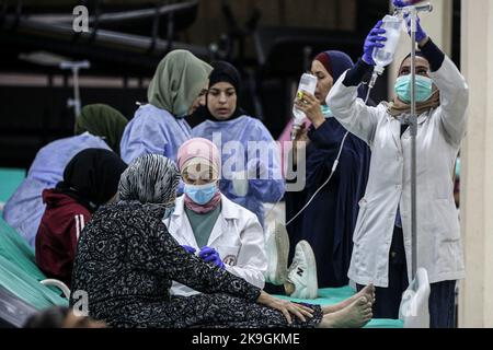 Bebnin, Libano. 28th Ott 2022. Il personale medico libanese si prende cura di una donna anziana, vittima dell'epidemia di colera, in un ospedale da campo nel villaggio libanese settentrionale di Bebnin. I rifugiati siriani nei campi di sfollamento sono vittime di un focolaio di colera in Libano, già colpiti da un crollo economico che ha ridotto l’accesso all’acqua potabile e agli ospedali in difficoltà. Credit: Marwan Naamani/dpa/Alamy Live News Foto Stock