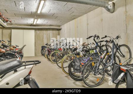 Ampio garage con porta bianca chiusa con moto e biciclette Foto Stock