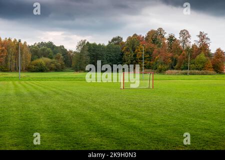 Un campo di allenamento di calcio in un paesaggio rurale autunnale. Erba lussureggiante perfettamente rifinita. Un campo da calcio situato in una splendida posizione. Polanka W Foto Stock