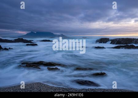 Vista iconica sulla Table Bay di Table Mountain e Città del Capo in una giornata nuvolosa al tramonto da Bloubergstrand nel Capo Occidentale. Sudafrica. Foto Stock