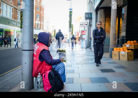 Londra - Ottobre 2022: Una persona senza tetto che vende le riviste Big Issue su Northcote Road, Clapham nel sud-ovest di Londra Foto Stock