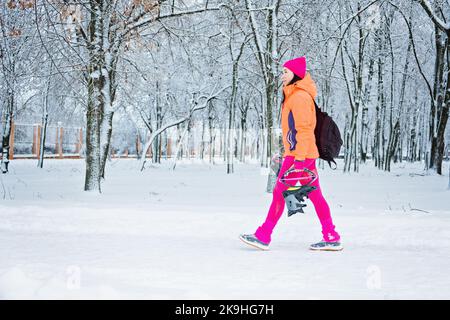 Donna che si prepara all'allenamento invernale all'aperto. Fitness invernale, esercizio in condizioni climatiche fredde. Sportswoman che si prepara all'allenamento all'aperto dentro Foto Stock