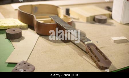 Riparazione della chitarra. Laboratorio di chitarra in legno. Incollaggio degli attrezzi. Dettagli di fabbricazione del caso. Foto Stock