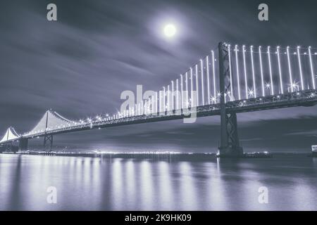 La luna piena sorge sopra il San Francisco-Oakland Bay Bridge, California, USA. Foto Stock