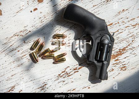 Un revolver nero, Ruger, 9mm, snub-nosed e un gruppo di 9mm proiettili. Foto Stock