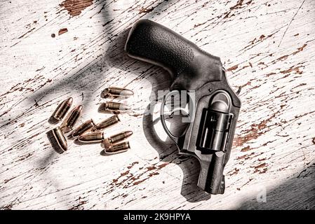Un revolver nero, Ruger, 9mm, snub-nosed con un raggruppamento di 9mm proiettili. Foto Stock