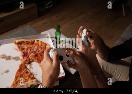 Primo piano delle mani di due amici che giocano ai videogiochi. Concetto di gioco. Foto Stock