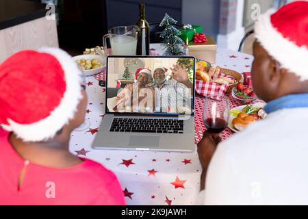Coppia africana americana anziana che ha videochiamata di natale con coppia africana americana anziana Foto Stock