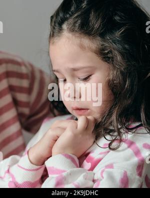 La bambina sconvolta che viene consolata dalla mamma Foto Stock