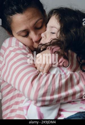 La bambina sconvolta che viene consolata dalla mamma Foto Stock