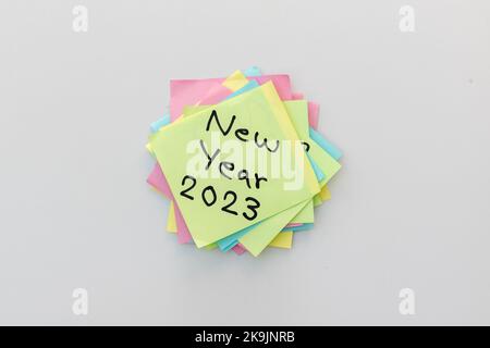 Anno nuovo 2023 scritto a mano su un foglietto adesivo giallo con sfondo bianco isolato Foto Stock