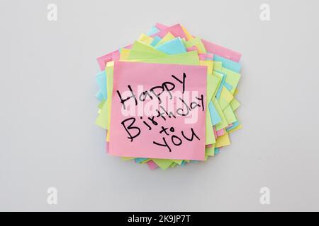 Buon compleanno a voi ha scritto a mano la nota su un blocco note appiccicoso Foto Stock
