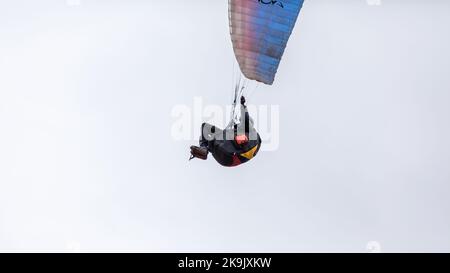 Skydiving sport estremi - paracadutista con paracadute dispiegato. Lo sportivo che vola su un parapendio. Bellissimo parapendio in volo su un dorso leggero Foto Stock