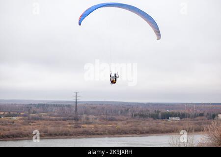 Skydiving sport estremi - paracadutista con paracadute dispiegato. Lo sportivo che vola su un parapendio. Bellissimo parapendio in volo su un dorso leggero Foto Stock