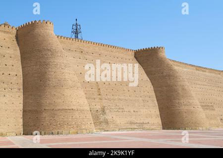 Frammento del muro della fortezza con due torri dell'antica fortezza di Arca in una giornata di sole. Bukhara, Uzbekistan Foto Stock