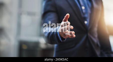 Unisciti a me e lascia prendere il controllo di questa città. Primo piano di un uomo d'affari irriconoscibile che estende una stretta di mano in città. Foto Stock