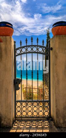 Vista sulle acque turchesi del Mar Mediterraneo e sulla costa di Roquebrune Cap Martin, nel sud della Francia vicino a Monaco, attraverso una porta ornata Foto Stock