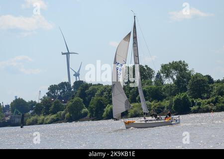 Amburgo, Germania. 11th giugno, 2022. Una nave a vela naviga nel vento sul fiume Elba di fronte a due turbine eoliche nel porto. Credit: Jonas Walzberg/dpa/Alamy Live News Foto Stock