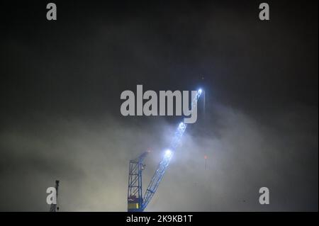 Amburgo, Germania. 26th Ott 2022. Le luci di una gru da porto brillano nella fitta nebbia mattutina. Credit: Jonas Walzberg/dpa/Alamy Live News Foto Stock