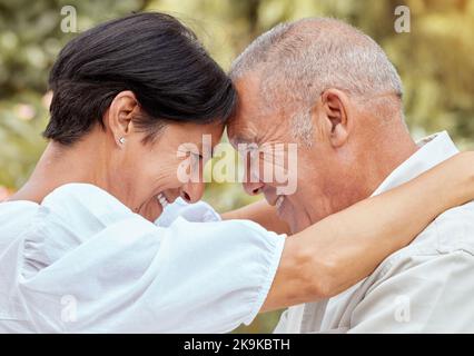 Coppia anziana, abbraccio e fronte con sorriso per amore, romanticismo e abbraccio in relazione felicità all'aperto. Felice uomo maturo e donna abbraccia Foto Stock