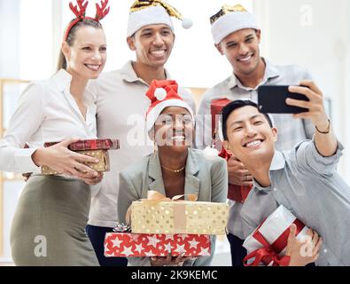 Felice, ufficio e festa di natale selfie di un evento aziendale con personale Diversity al telefono. Lavoro, amici e gruppo di dipendenti insieme Foto Stock