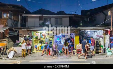 Una tipica scena di strada notturna in una zona trafficata di Cebu City, Filippine Foto Stock