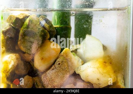 Fuoco morbido primo piano di un vaso di vetro con pietre, acqua e bambù Foto Stock