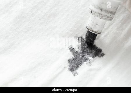 Punta per marcatura in inchiostro nero, graffiatura su tessuto bianco, primo piano con messa a fuoco morbida Foto Stock
