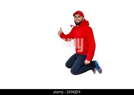 Felice uomo caucasico sopportato sorridendo e saltando in aria, mostrando pollici in su. Foto Stock