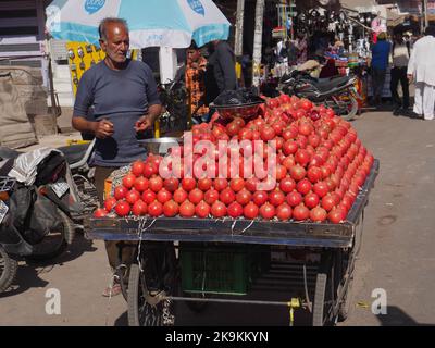 Bikaner Rajasthan, India : 14 gennaio 2018 – venditore di frutta melograna che vende melograni su stalla, camion tenuto in mano Foto Stock