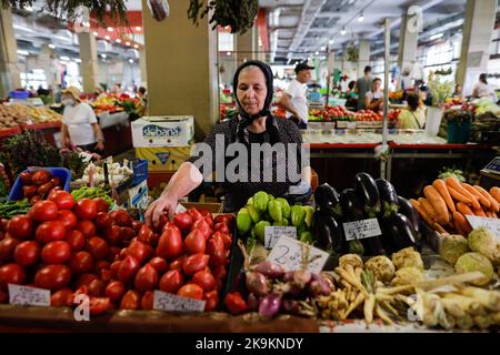 Bucarest, Romania - 4 agosto 2022: Profondità di campo poco profonda (fuoco selettivo) dettagli con una donna senior che vende ortaggi in uno stand nel mercato Obor Foto Stock