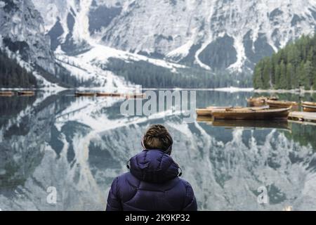 Giovane donna gode di vista panoramica sul lago di Braies con la capanna e le barche sulle montagne delle Dolomiti e Seekofel al mattino | Lago di Braies / Pragser Wil Foto Stock