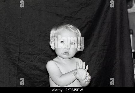 Ritratto di un bambino di un anno su sfondo scuro. Foto Stock