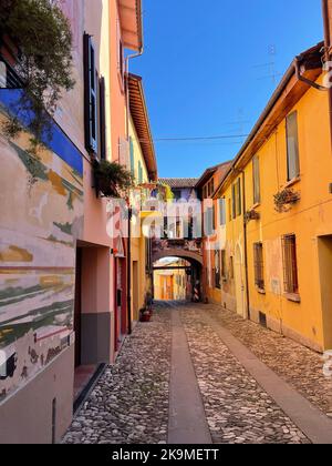 Dozza, Italia. Murales sulla facciata di edifici storici sulla pittoresca Via Edmondo de Amicis. Foto Stock