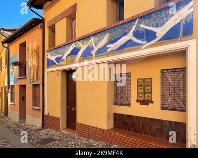 Dozza, Italia. Murales sulla facciata di edifici storici. 'Uomini che volano e le vigne', di Paolo Scarpa. Foto Stock